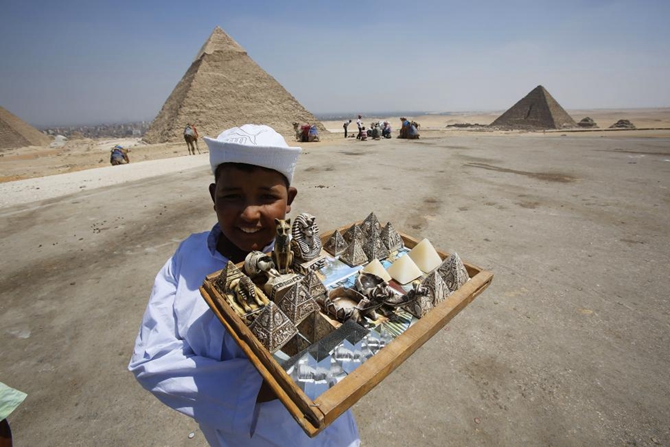 A child vendor waits for tourists to sell them souvenirs at the Giza Pyramids, on the outskirts of Cairo